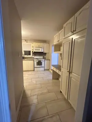 a kitchen with white cabinets and a tile floor at 3 Room Set for Up to 8 people- 10 minutes from Kitchener Airport, Walking to Transit in Kitchener