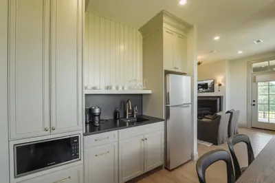 a kitchen with white cabinets and a white refrigerator at The Penrose Suites in Saint Marys