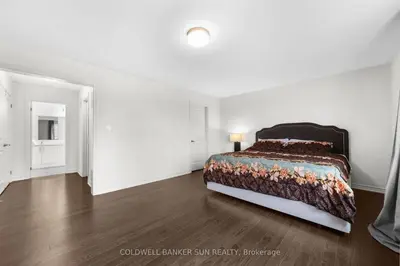a bedroom with a bed in a white room at Cozy 5 bedrooms & 5 bathrooms House in Tottenham