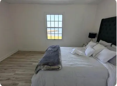 a bedroom with a large bed with a blanket on it at Cottage on Private Beach in Penetanguishene