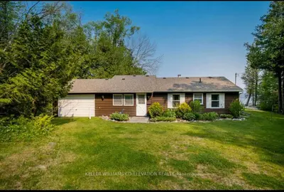 a house with a large yard in front of it at Cottage on Private Beach in Penetanguishene