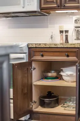 a kitchen with wooden cabinets and a counter with dishes at PetFriendly, 2 KingBeds, Gym, Pool, Netflix in Shanty Bay