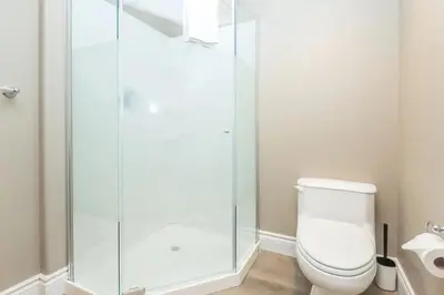 a bathroom with a toilet and a glass shower at PetFriendly, 2 KingBeds, Gym, Pool, Netflix in Shanty Bay