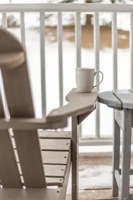 a coffee cup sitting on a table next to a chair at PetFriendly, 2 KingBeds, Gym, Pool, Netflix in Shanty Bay