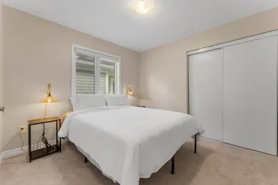 a white bedroom with a large bed and a window at Spacious Family Getaway Near Nature & Dining in Cambridge