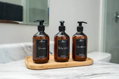 three bottles of soap sitting on a wooden cutting board at Spacious Family Getaway Near Nature & Dining in Cambridge