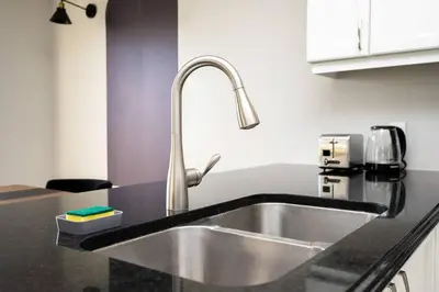 a kitchen sink with a faucet on a counter at Spacious Family Getaway Near Nature & Dining in Cambridge