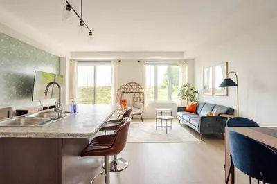 a kitchen and living room with a sink and a couch at Stylish 4br Fast Wifi Sleeps 10 in Barrie