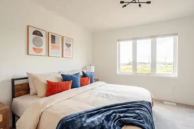 a bedroom with a large bed with orange and blue pillows at Stylish 4br Fast Wifi Sleeps 10 in Barrie