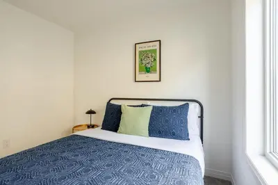 a bedroom with a bed with blue and green pillows at Stylish 4br Fast Wifi Sleeps 10 in Barrie