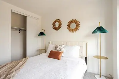 a bedroom with a bed with two mirrors on the wall at Stylish 4br Fast Wifi Sleeps 10 in Barrie