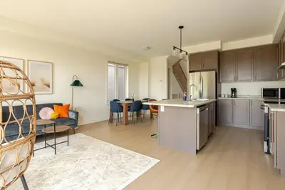 an open kitchen and living room with a couch and a table at Stylish 4br Fast Wifi Sleeps 10 in Barrie