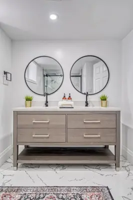 a bathroom with two mirrors above a sink at Modern 3 Bdr Homeapt Mins To Notlwineriesfalls in St. Catharines
