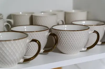 a row of white cups sitting on a shelf at Modern 3 Bdr Homeapt Mins To Notlwineriesfalls in St. Catharines