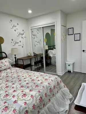 a bedroom with a bed and a mirror with flowers on the wall at Private Room Near Airport K3 in Mississauga