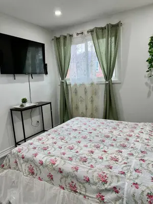 a bedroom with a bed with a floral bedspread at Private Room Near Airport K3 in Mississauga