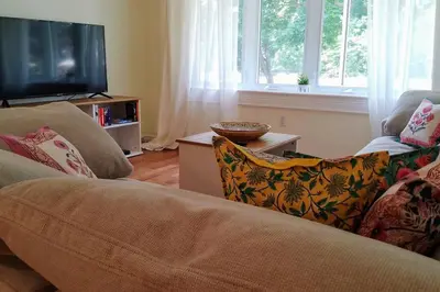 a living room with a couch and a flat screen tv at Birdsong Bungalow in Port Dover