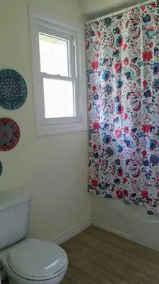 a bathroom with a toilet and a window at Birdsong Bungalow in Port Dover