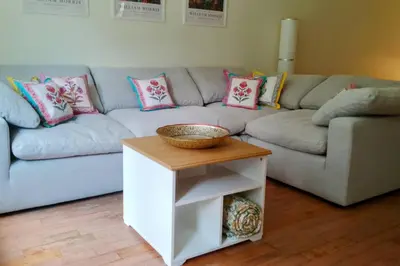a living room with a blue couch and a table at Birdsong Bungalow in Port Dover
