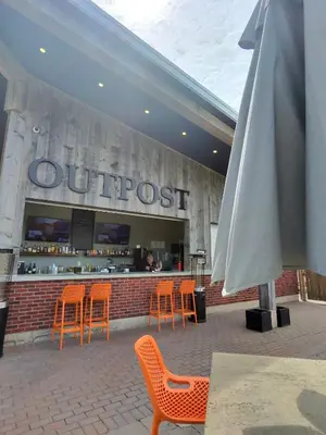 an outdoor restaurant with orange chairs and an umbrella at Redwood Suite in Niagara on the Lake