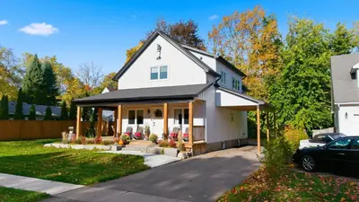 a white house with a black roof at Spruce Suite in Niagara on the Lake