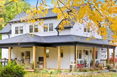 a white house with a black roof at Spruce Suite in Niagara on the Lake