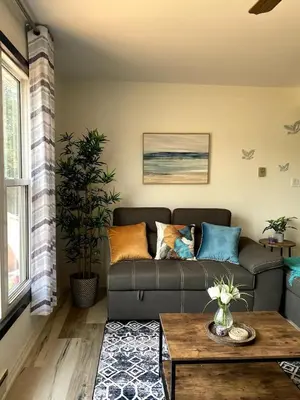 a living room with a couch and a table at Peaceful and Heavenly Private Water Front Cottage on 100 Acres of Scenic Beauty- Trent Lakes in Kinmount