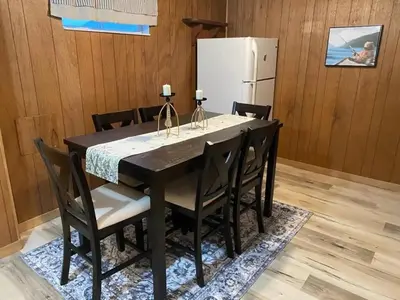a black dining room table with chairs and a white refrigerator at Peaceful and Heavenly Private Water Front Cottage on 100 Acres of Scenic Beauty- Trent Lakes in Kinmount