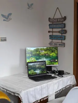 a laptop computer sitting on a table with a monitor at Peaceful and Heavenly Private Water Front Cottage on 100 Acres of Scenic Beauty- Trent Lakes in Kinmount