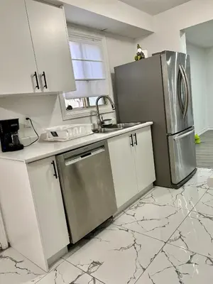 a kitchen with white cabinets and a stainless steel refrigerator at Private Room Near Airport K5 in Mississauga