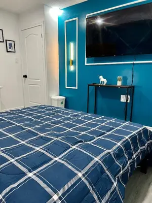 a blue bedroom with a bed and a tv at Private Room Near Airport K4 in Mississauga