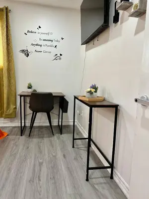 a room with two tables and a chair and a wall at Private Room Near Airport K2 in Mississauga
