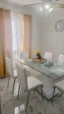 a dining room with a glass table and white chairs at Private Room Near Airport K2 in Mississauga