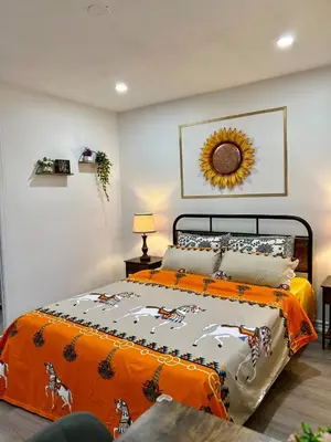 a bedroom with a bed with an orange blanket at Private Room Near Airport K2 in Mississauga