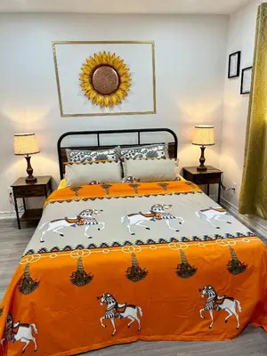 a bed with an orange blanket with horses on it at Private Room Near Airport K2 in Mississauga