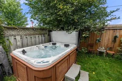 a hot tub in a backyard with a tree at Ninos place in Hamilton