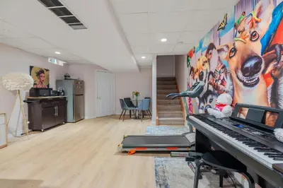 a room with a piano and a wall with a mural at Ninos place in Hamilton