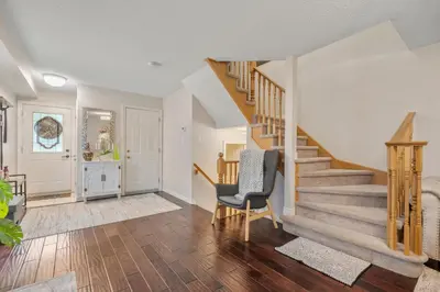 a living room with a staircase and a chair at Ninos place in Hamilton