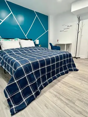 a bedroom with a blue and white plaid blanket on a bed at Private Room Near Airport K7 in Mississauga