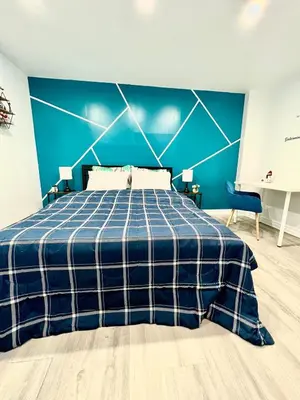 a blue bedroom with a bed and a blue wall at Private Room Near Airport K7 in Mississauga