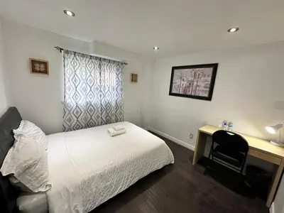 a hotel room with a bed and a desk with a chair at Riverwood Home-Entire Rental Unit in Mississauga