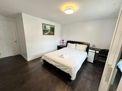 a bedroom with a bed with a white comforter at Riverwood Home-Entire Rental Unit in Mississauga