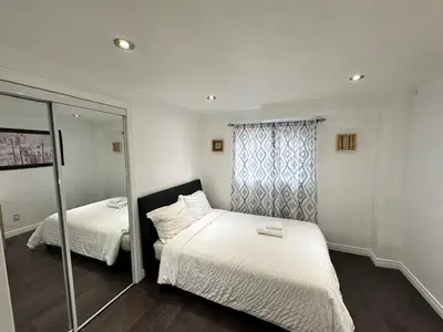 a small bedroom with two beds and a mirror at Riverwood Home-Entire Rental Unit in Mississauga