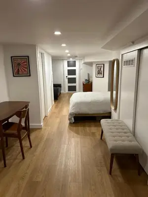 a bedroom with a bed and a table and a desk at Lower level newly renovated studio apartment in central downtown location in Toronto