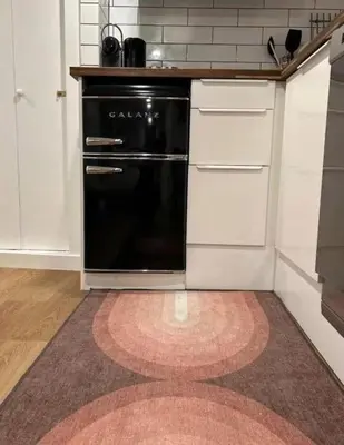 a kitchen with a black oven and white cabinets at Lower level newly renovated studio apartment in central downtown location in Toronto