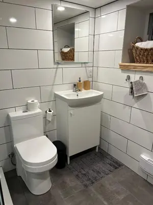 a white bathroom with a toilet and a sink at Lower level newly renovated studio apartment in central downtown location in Toronto