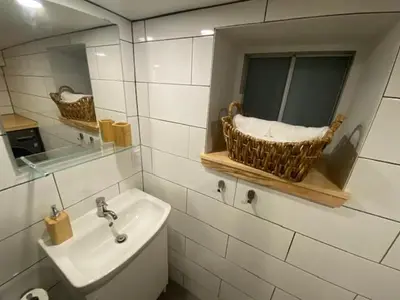 a bathroom with a sink and a mirror at Lower level newly renovated studio apartment in central downtown location in Toronto