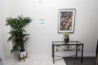 a white room with a table and two plants at JNShortStay- Niagara Falls Area Hidden Gem in Welland