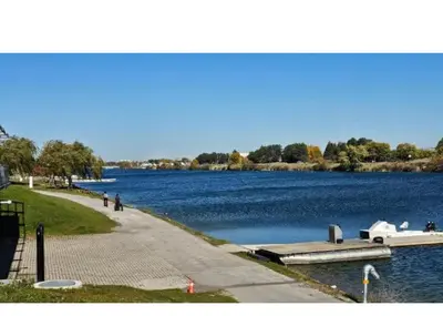a river with a pier and a boat in the water at JNShortStay- Niagara Falls Area Hidden Gem in Welland