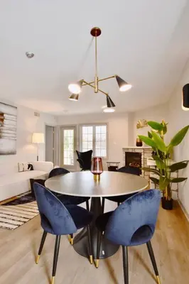 a living room with a table and blue chairs at Stunning Condo with Access to Pool in Shanty Bay